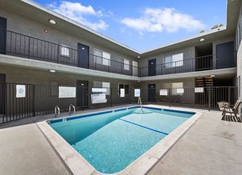 A large indoor swimming pool in a building with balconies.